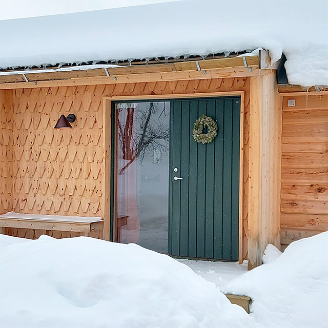 Grönmålad ytterdörr i furu och gran med sidoljus